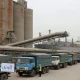نمایی مستند از سیلوها و لجستیک بندری غلات و کامیون‌های حمل، برای مفهوم اسپرد قیمت نهاده‌ها از بندر تا بازار داخل و تفاوت‌های استانی